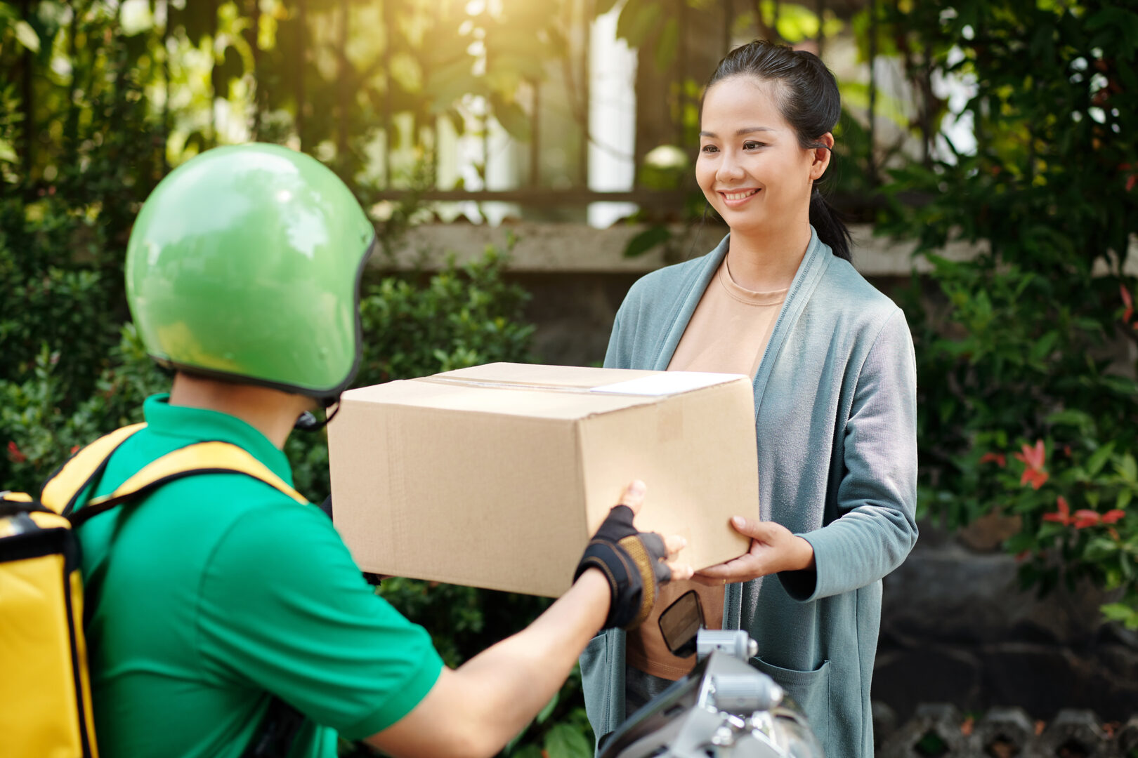 Woman receiving package from delivery driver
