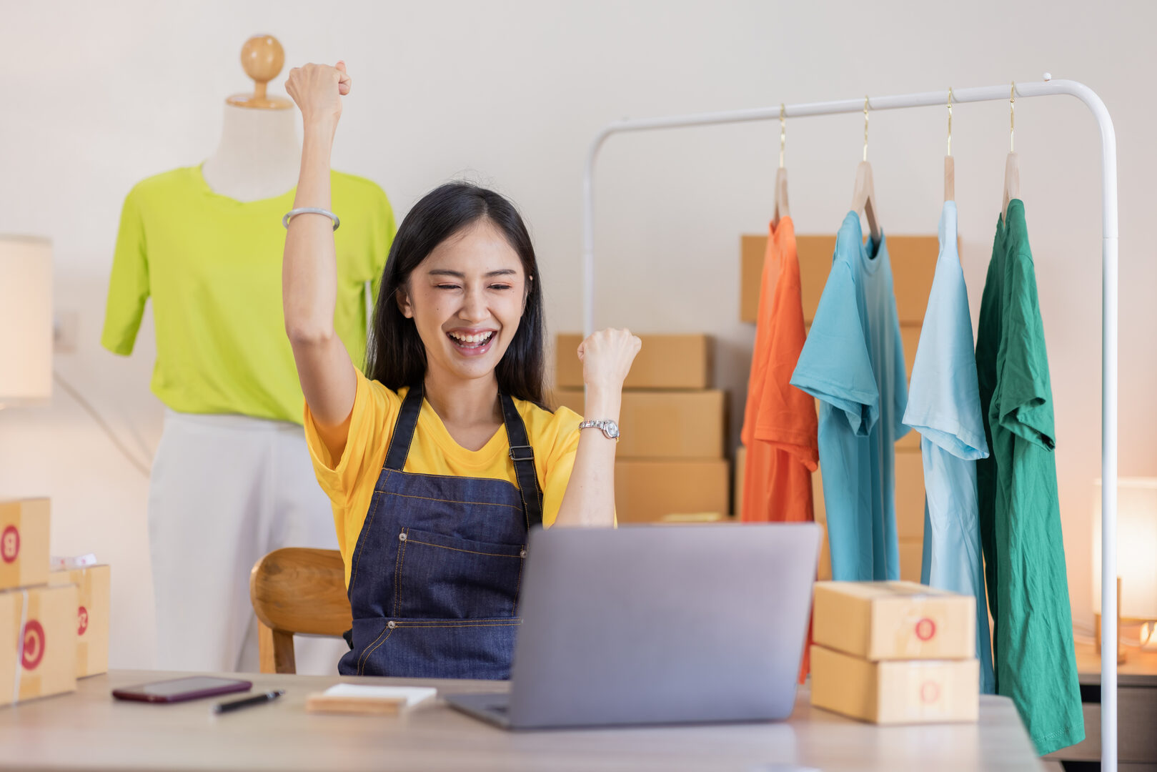 Shop owner celebrating success at laptop